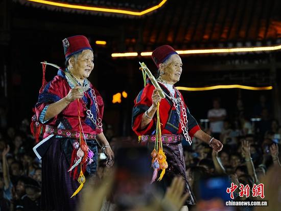 两位苗族老人在凯里苗侗风情园内举办的贵州“村T”舞台上走秀，吸引众多游客前来观看拍照。贵州“村T”全称是贵州省和美乡村非遗民族服饰T台秀，起源于2024年7月苗族设计师杨春林发起的草根走秀，是一个面向中国以及全世界展示非遗服饰的公益T台秀。周燕玲 摄