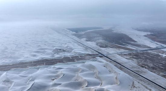 皑皑白雪覆盖广袤沙海。阿巴拜科日摄