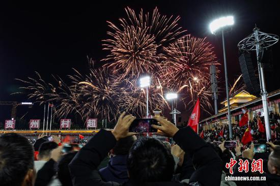 1月1日晚，贵州省黔东南苗族侗族自治州榕江县元旦专场无人机编队表演、烟花秀在“村超”球场上演。图为民众在拍摄烟花秀。