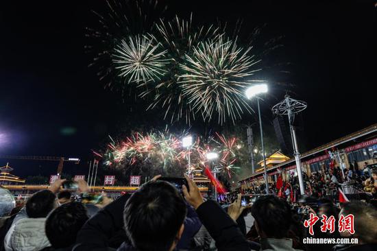 1月1日晚，贵州省黔东南苗族侗族自治州榕江县元旦专场无人机编队表演、烟花秀在“村超”球场上演。图为民众在拍摄烟花秀。