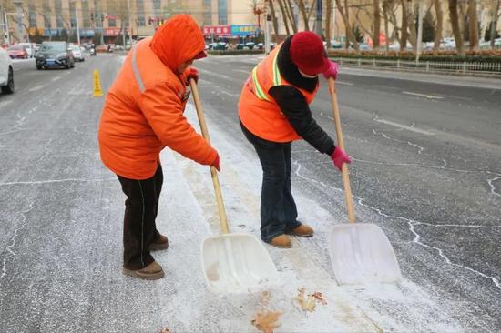 环卫工人清除道路积雪。阿的拉 摄0