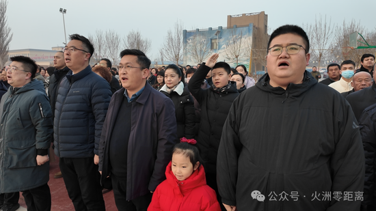 干部群众行注目礼，齐声高唱国歌。 胡源摄