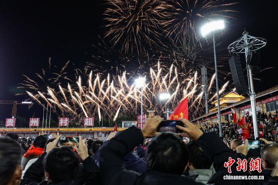 1月1日晚，贵州省黔东南苗族侗族自治州榕江县元旦专场无人机编队表演、烟花秀在“村超”球场上演。图为民众在拍摄烟花秀。