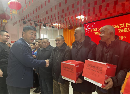 为荣获“奋进之星”村民颁发奖品。e