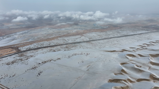 皑皑白雪覆盖广袤沙海。阿巴拜科日摄