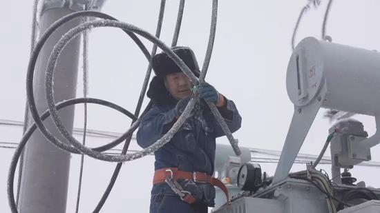 国家电网工作人员在35KV九运街变电站10KV九农线，安装调压器。张鹏 摄