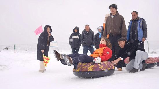 游客参加雪圈追逐赛。