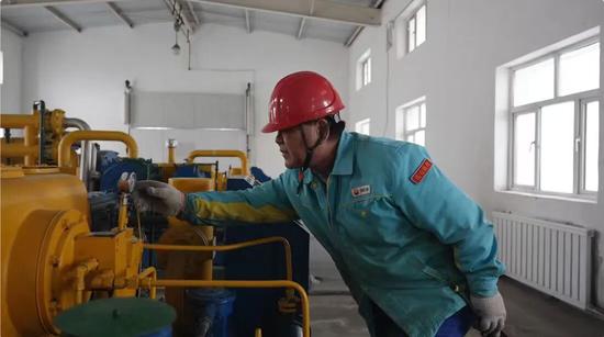 在阜康市第二水厂的设备车间内，巡检人员正俯身仔细查看每一台供水设备的运行参数。张鹏 摄