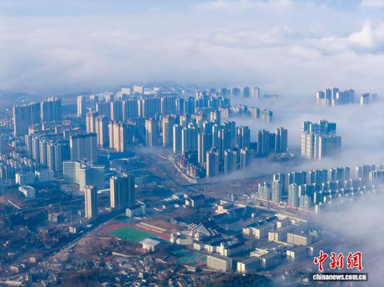 1月3日清晨，贵州省毕节市威宁彝族回族苗族自治县城中出现平流云美景，城市高楼在云雾中若隐若现，美不胜收，宛如“天空之城”。管庆巍 摄