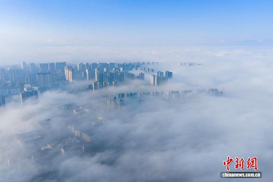 1月3日清晨，贵州省毕节市威宁彝族回族苗族自治县城中出现平流云美景，城市高楼在云雾中若隐若现，美不胜收，宛如“天空之城”。管庆巍 摄