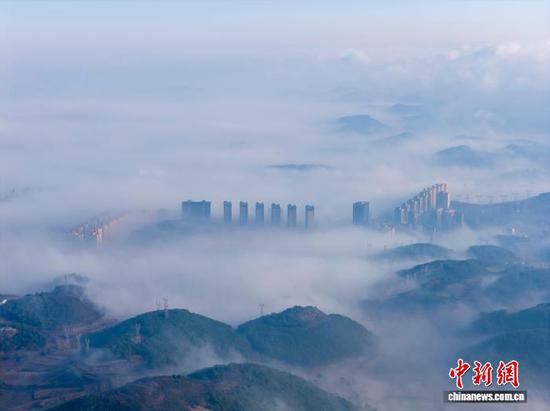 1月3日清晨，贵州省毕节市威宁彝族回族苗族自治县城中出现平流云美景，城市高楼在云雾中若隐若现，美不胜收，宛如“天空之城”。管庆巍 摄