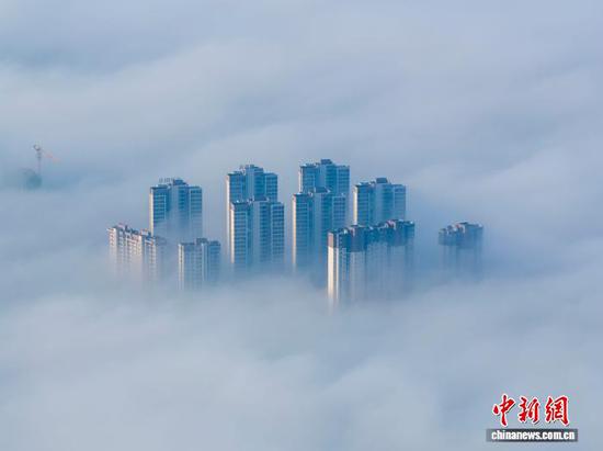 1月3日清晨，贵州省毕节市威宁彝族回族苗族自治县城中出现平流云美景，城市高楼在云雾中若隐若现，美不胜收，宛如“天空之城”。管庆巍 摄