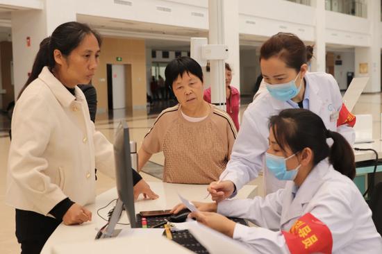 清镇市第一人民医院内，引导员在向患者家属讲解就医程序