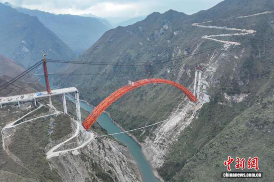 1月5日，随着最后一节钢拱精准吊装到位，贵州安顺至盘州高速公路古牛河特大桥顺利合龙。　记者 瞿宏伦 摄