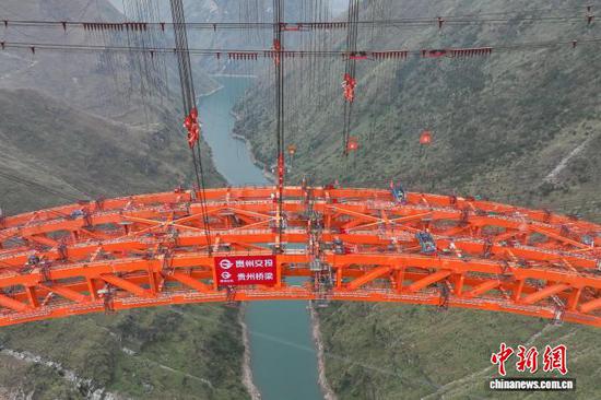 1月5日，随着最后一节钢拱精准吊装到位，贵州安顺至盘州高速公路古牛河特大桥顺利合龙。　记者 瞿宏伦 摄