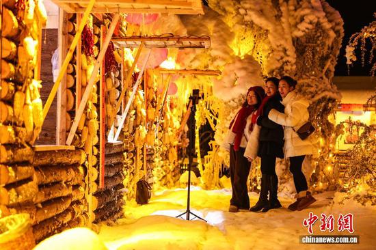 1月7日晚，游客在贵州省六盘水市钟山区“南国雪乡”项目内自拍。该项目由钟山区梅花山旅游景区凭借梅花山滑雪场的核心优势，以“厚雪压木屋、红灯映炊烟”为设计理念打造，旨在让南方游客无需北上即可邂逅地道雪乡风情，打造沉浸式文旅新体验。