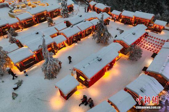 1月7日晚，游客在贵州省六盘水市钟山区“南国雪乡”项目内游玩。该项目由钟山区梅花山旅游景区凭借梅花山滑雪场的核心优势，以“厚雪压木屋、红灯映炊烟”为设计理念打造，旨在让南方游客无需北上即可邂逅地道雪乡风情，打造沉浸式文旅新体验。