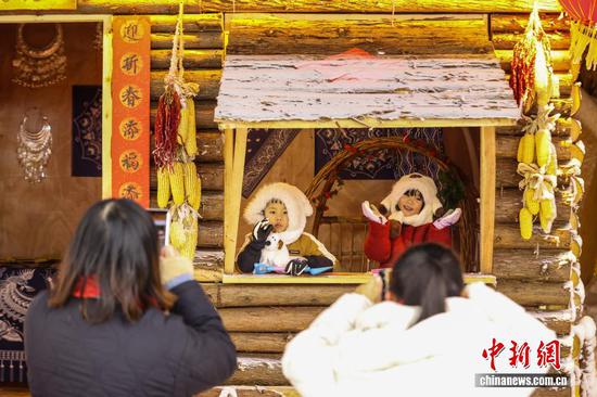 1月7日晚，游客在贵州省六盘水市钟山区“南国雪乡”项目内拍照。该项目由钟山区梅花山旅游景区凭借梅花山滑雪场的核心优势，以“厚雪压木屋、红灯映炊烟”为设计理念打造，旨在让南方游客无需北上即可邂逅地道雪乡风情，打造沉浸式文旅新体验。