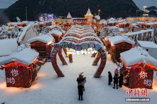 1月7日晚，游客在贵州省六盘水市钟山区“南国雪乡”项目内游玩。该项目由钟山区梅花山旅游景区凭借梅花山滑雪场的核心优势，以“厚雪压木屋、红灯映炊烟”为设计理念打造，旨在让南方游客无需北上即可邂逅地道雪乡风情，打造沉浸式文旅新体验。