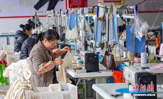 图为工人在从江县贯洞镇美娥社区一家制衣车间赶制服装订单产品。卢忠南 摄