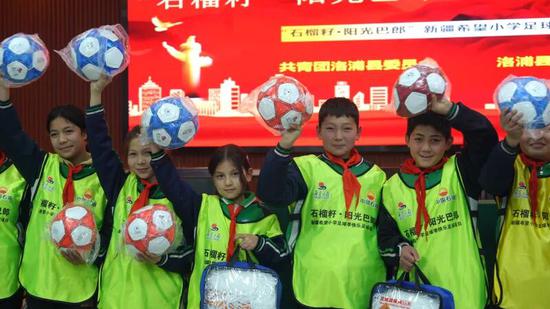 孩子們領(lǐng)到足球很開心。