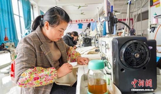 图为工人在从江县贯洞镇美娥社区一家制衣车间赶制服装订单产品。卢忠南 摄
