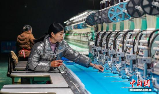 图为工人在从江县贯洞镇美娥社区一家刺绣生产车间赶制刺绣订单产品。卢忠南 摄