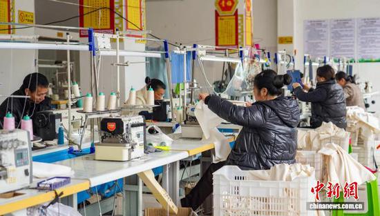 图为工人在从江县贯洞镇美娥社区一家制衣车间赶制服装订单产品。卢忠南 摄