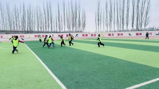 同學(xué)們?cè)谇驁錾嫌眯戮栀?zèng)的足球裝備進(jìn)行比賽。