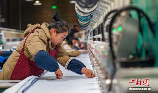 图为工人在从江县贯洞镇美娥社区一家刺绣生产车间赶制刺绣订单产品。卢忠南 摄