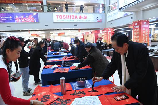 图为陈中华（前排右一）在活动现场给民众写春联。记者 蒋雪林 摄