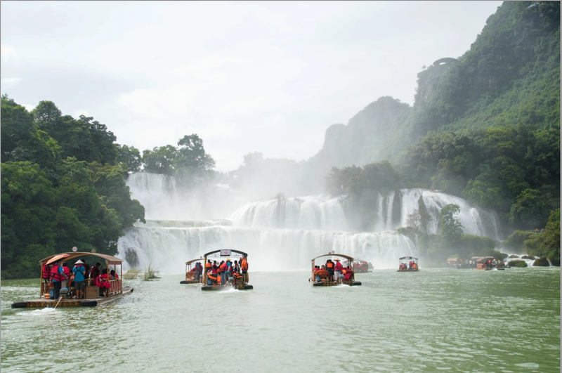 游客在位于广西崇左市大新县的跨境旅游合作区——中越德天(板约)瀑布跨境旅游合作区乘船观光。 中新社记者 陈冠言∕摄