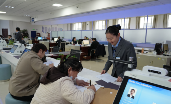 image在塔城地区政务服务与公共资源交易中心，工作人员为群众办理业务。马合巴勒·木尔扎汗摄