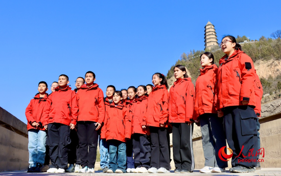 新疆学子在陕西延安宝塔山下朗诵诗歌《延安，我把你追寻》。人民网 李龙摄