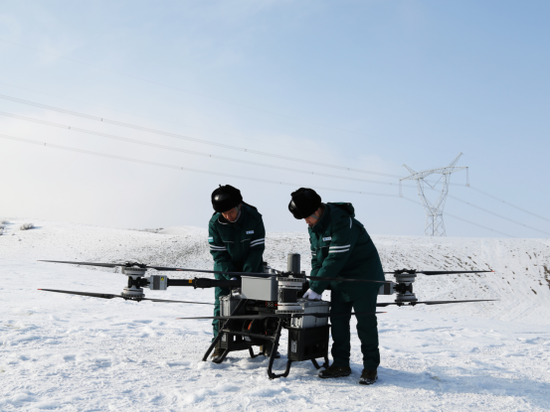 1月15日，新疆送变电公司员工在750千伏凤亚二线开展大载重无人机除冰准备作业。（彭森 摄）