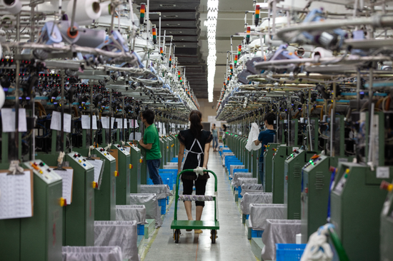 浙江耶米玛服饰有限公司生产车间内，工人在各自岗位上有序作业。（松阳县委宣传部供稿）