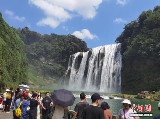 图为游客在贵州黄果树瀑布游玩。记者 周燕玲 摄 图为游客在贵州黄果树瀑布游玩。记者 周燕玲 摄