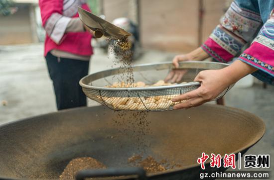 筛选炒制好的米团。张帆 摄