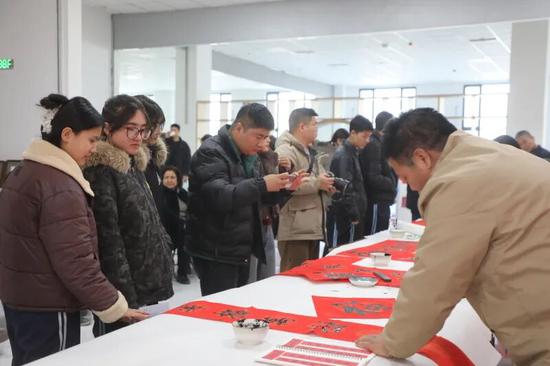 市民参观书法爱好者写对联。阿的拉 摄