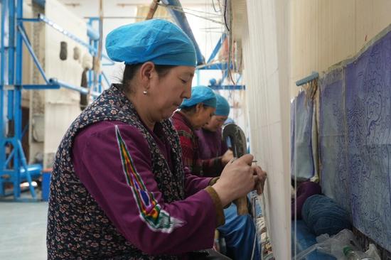 织工正在编织地毯。努尔古再丽 摄