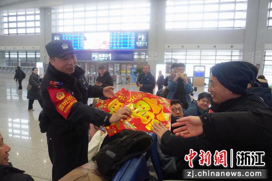 2月2日,民警给旅客送福字。嵊州新昌站派出所 供图 2月2日,民警给旅客送福字。嵊州新昌站派出所 供图