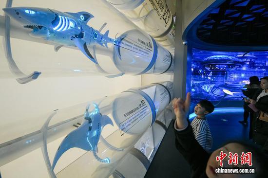 1月30日，天津，观众在“未来海洋”展厅参观各种海洋仿生机器人。当日，位于天津滨海新区的国家海洋博物馆“未来海洋”展厅正式向公众开放。展厅设置了深蓝召唤、时空切片、深海下潜仓、深海空间站、生物基因库、海底隧道、深海交通站、浮冰剧场等主题展区，以沉浸式与交互式科技手段，为观众呈现出未来海洋探索与开发的科幻景象。中新社记者 佟郁 摄