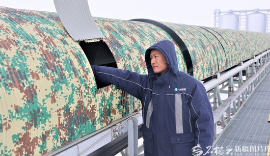 2月1日，在位于呼图壁县石梯子哈萨克族乡的呼图壁县输煤廊道现场，呼图壁县九洲恒昌供应链管理有限公司巡检员在查看输煤廊道运行情况。程勇摄