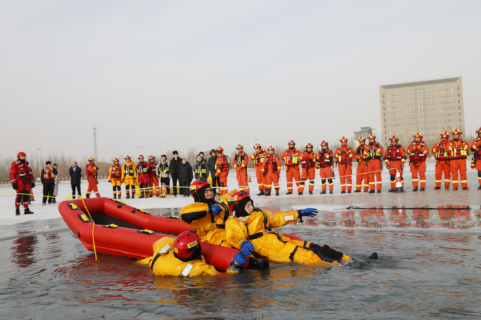 图为演练现场，消防救援人员利用充气船救援技术营救落水群众。