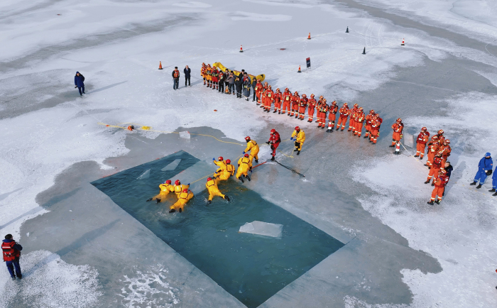 图为演练中，消防救援人员正在移除冰块。