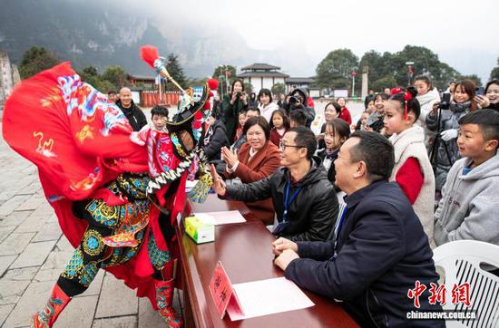 图为村民和游客零距离观看川剧变脸。史开心 摄