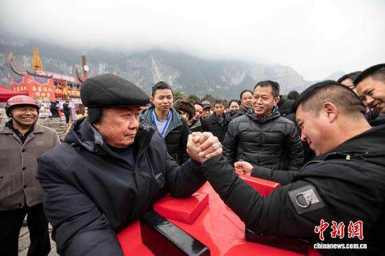 图为村民在进行扳手腕比赛。史开心 摄