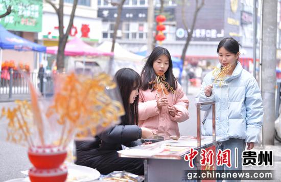 余庆县中等职业学校学生正在街头制作糖画。白青青摄