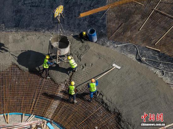 图为2月4日工人在赫章县水塘堡乡猪拱塘铅锌矿建设现场浇注混凝土。罗大富 摄