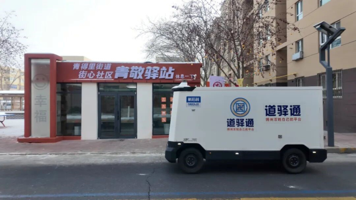 街心社区内，无人配送车沿道路行驶。

